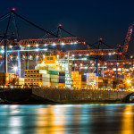 MOOC Summaries - International Business - Trade - Cargo ship loaded in New York container terminal at night viewed from Elizabeth NJ across Elizabethport reach.